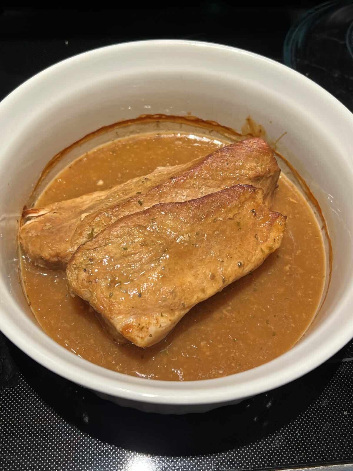 Image of the pork roast cooked in a dish pulled out of the oven. 