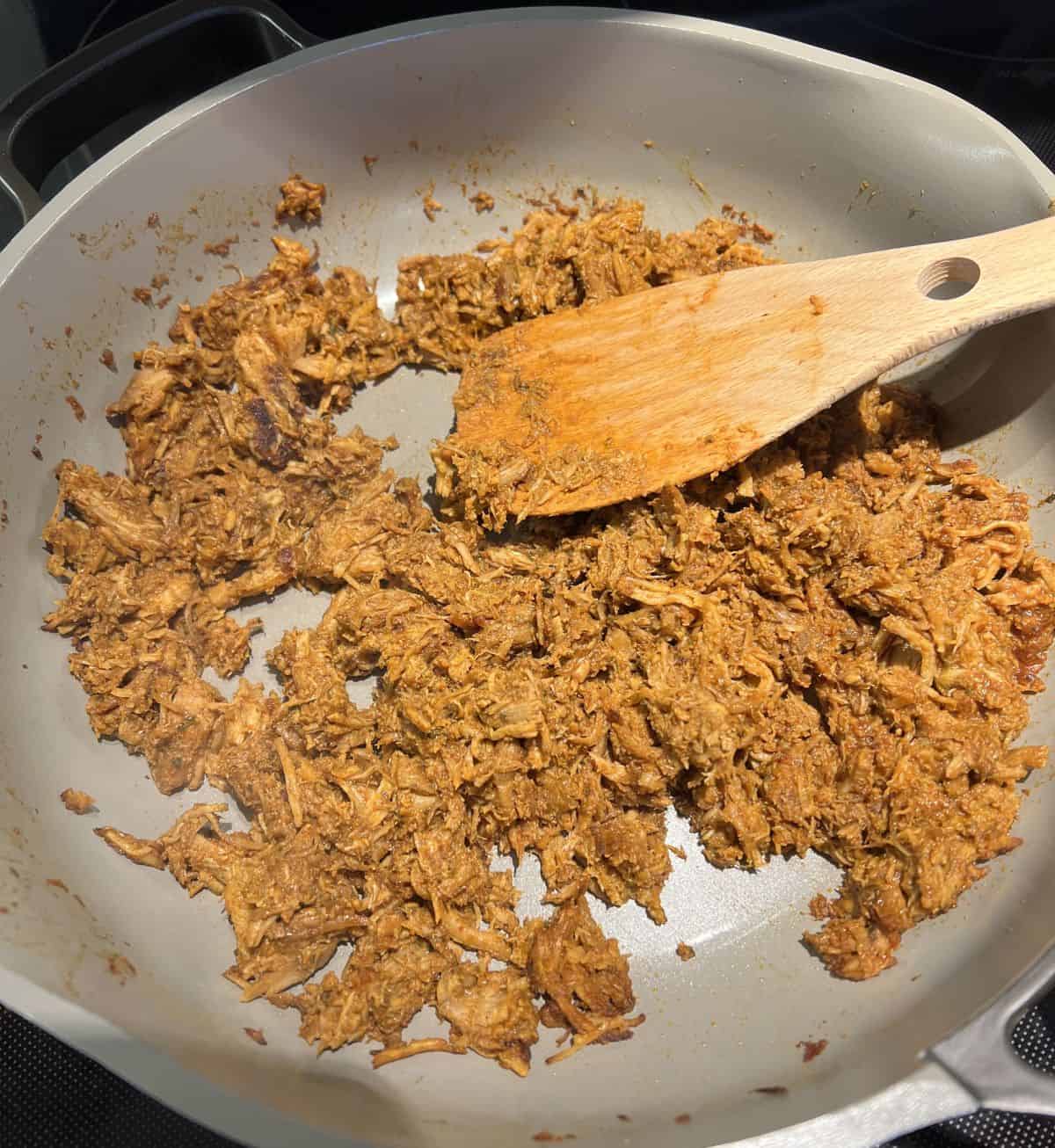 Image of the pork carnitas being heated in a pan. 