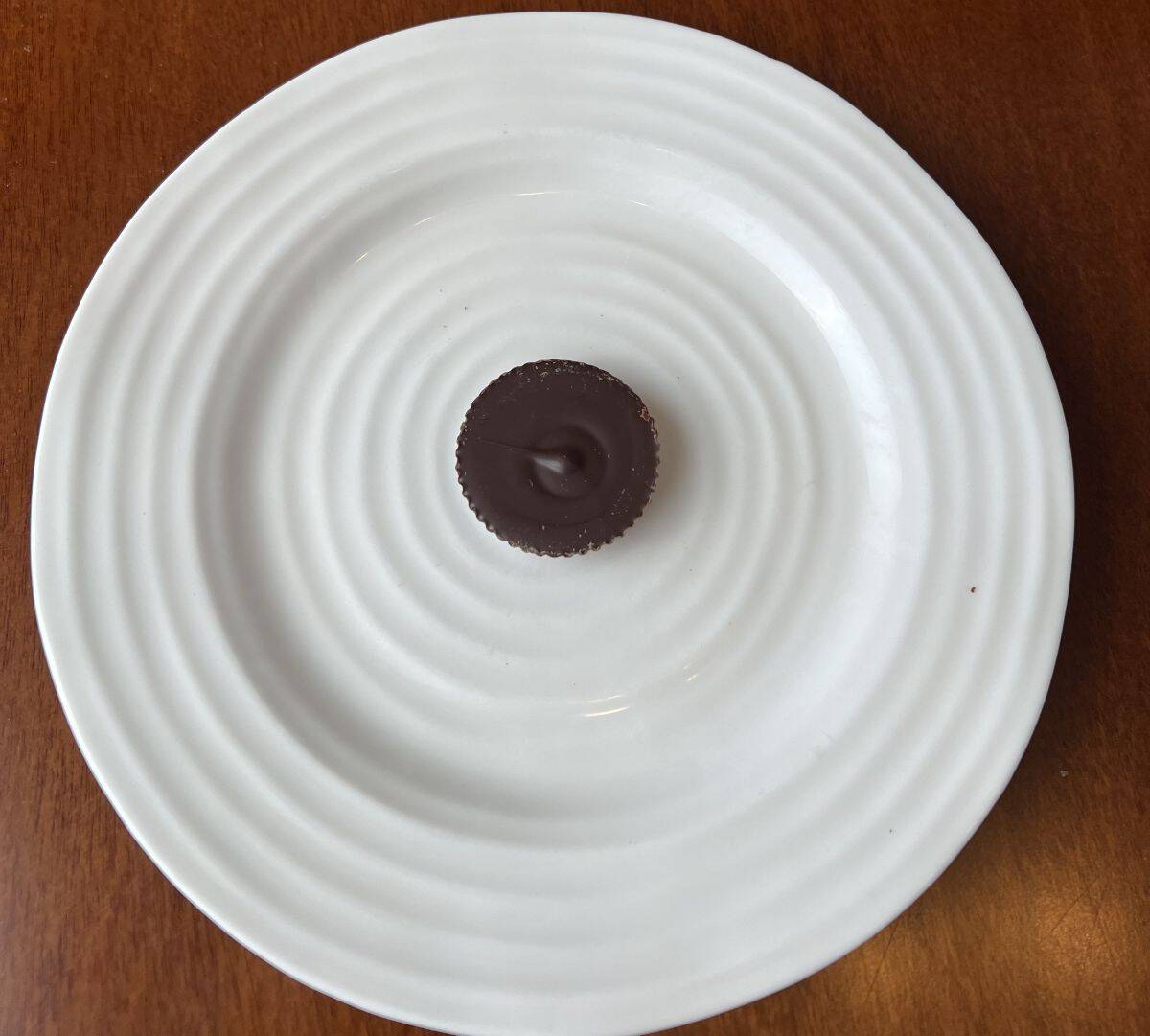 Image of one passion fruit chocolate cup served on a white plate. 