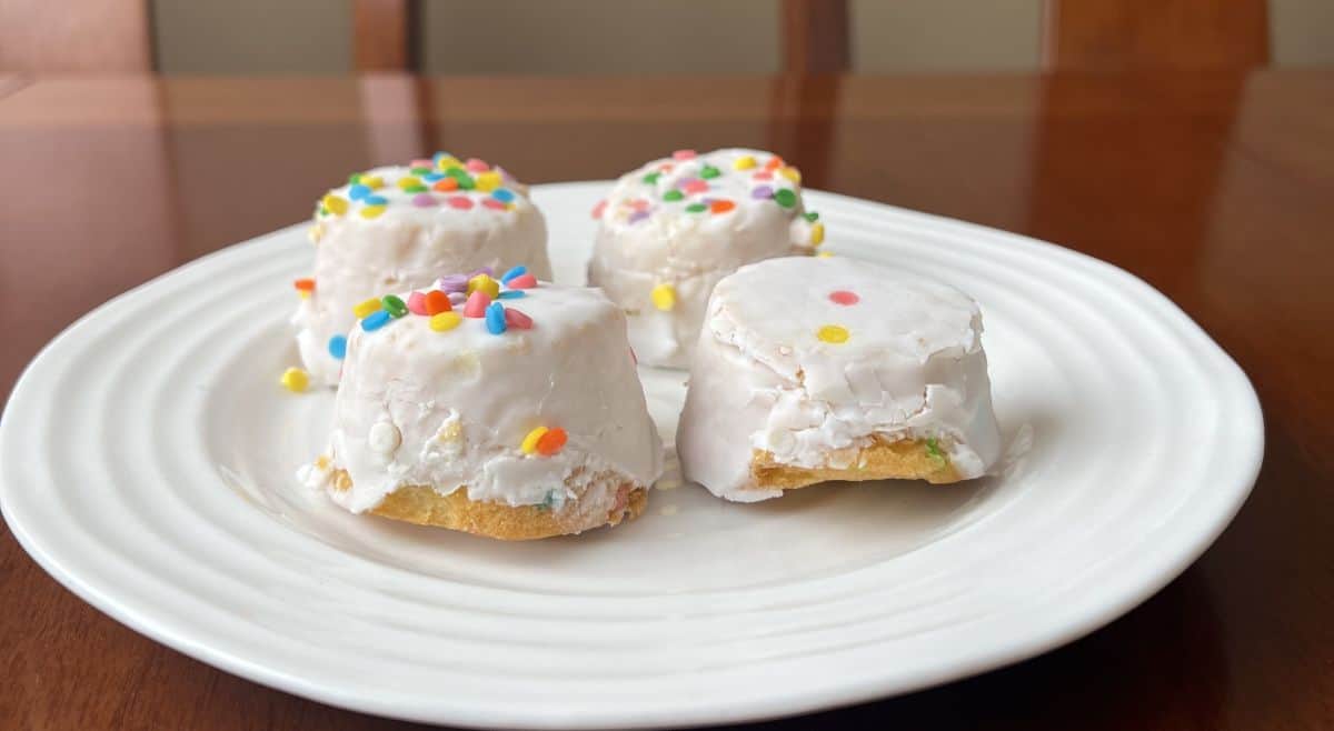 Sideview image of four cake bites served on a white plate.