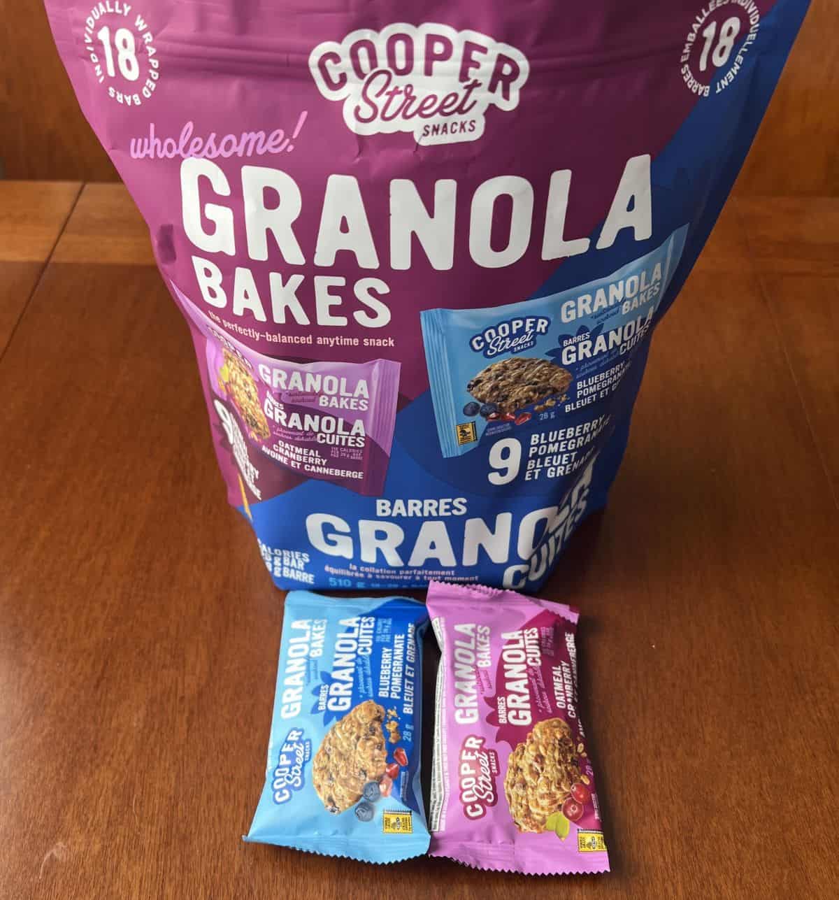 Image of two packaged granola bakes sitting in front of a granola bakes bag.