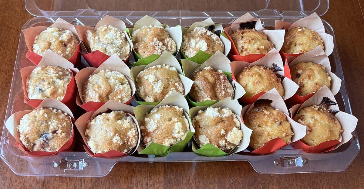 Image of 18 mini filled muffins in a plastic package. They are in green and red muffin cups. 