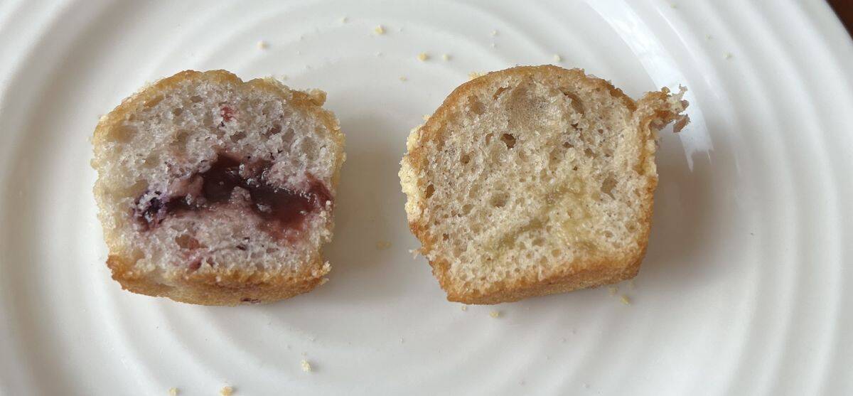 Image of two mini muffins cut in half served on a white plate. One has berry filling and one has apple filling.