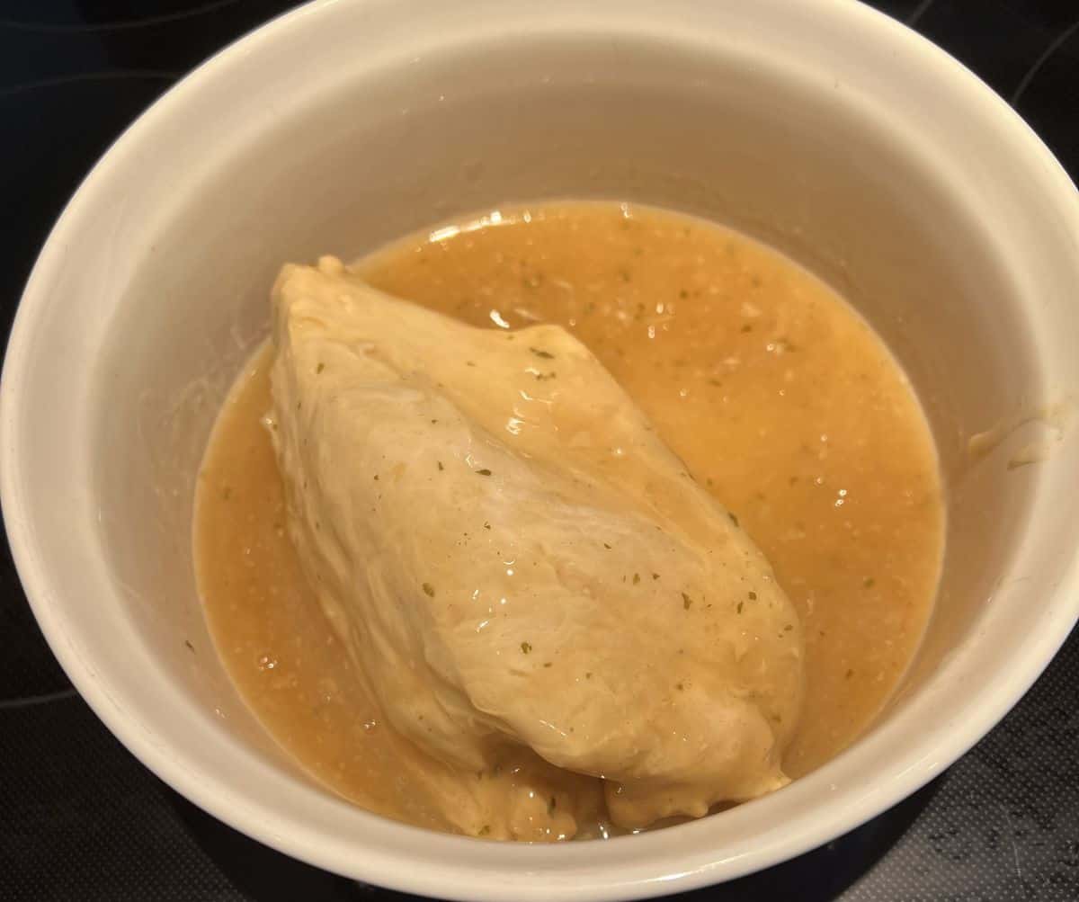 Image of a turkey breast in gravy ready to be cooked in the oven.