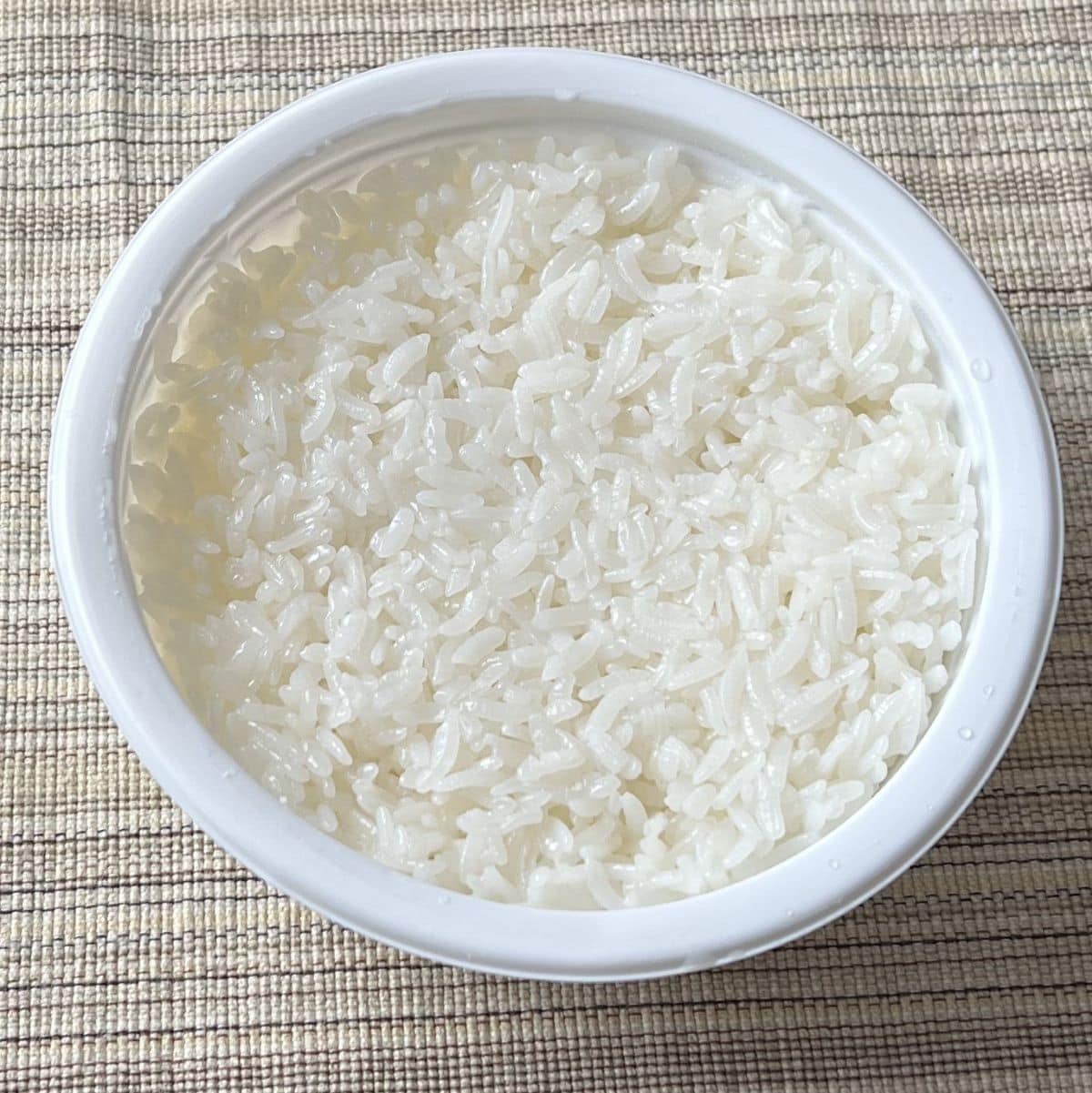 Top down image of a container of cooked white rice.