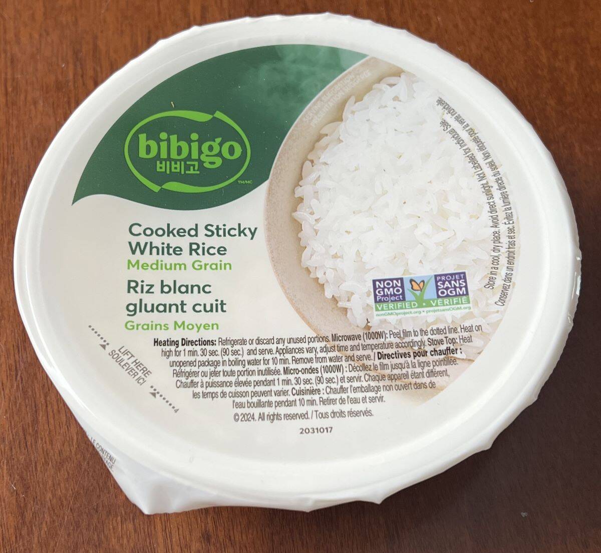 Image of one sealed plastic container of rice sitting on a table.