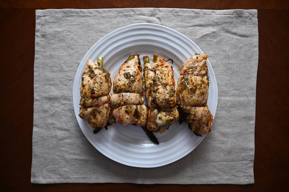 Image of four cooked chicken breasts served on a white plate.