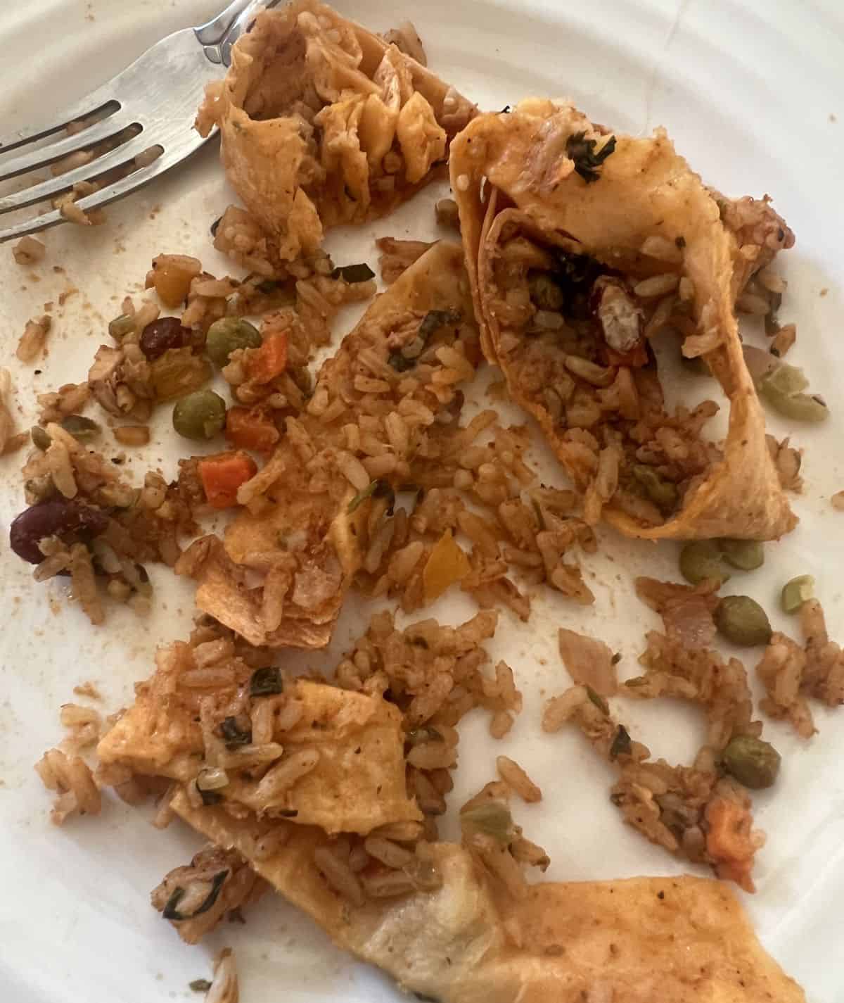 Image of the pork Carnita burrito deconstructed so you can see the rice, tortilla and filling on a plate. 