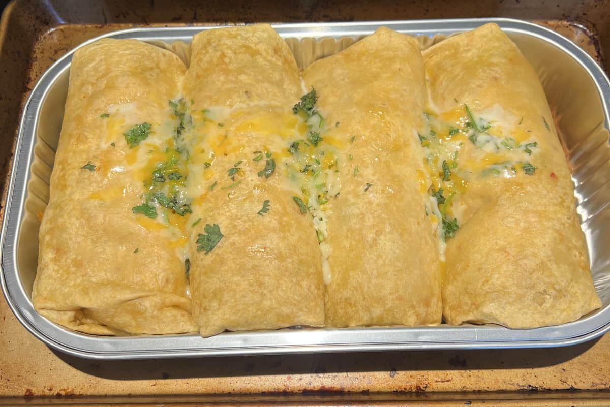 Image of the tray of burritos on a cookie sheet after being heated in the oven.