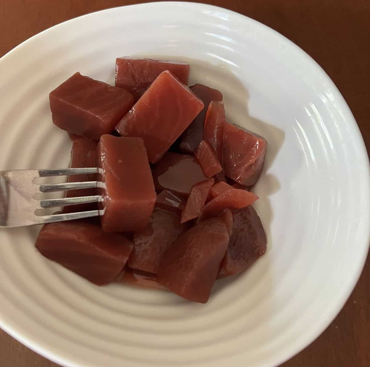 Image of a bowl of beet & onion salad served in a white bowl.