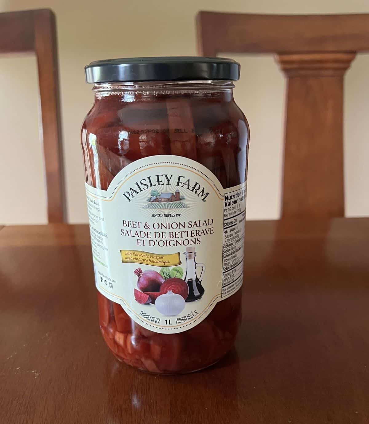 Image of a jar of the Costco Paisley Farm Beet & Onion Salad sitting on a table unopened.