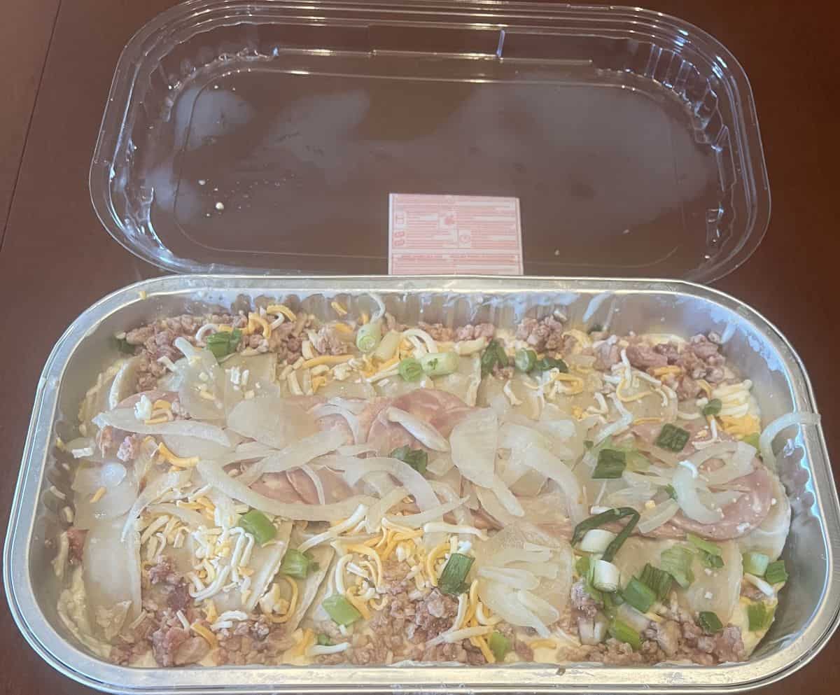 Image of the pierogi bake container on a table with the lid off so you can see the uncooked bake. 