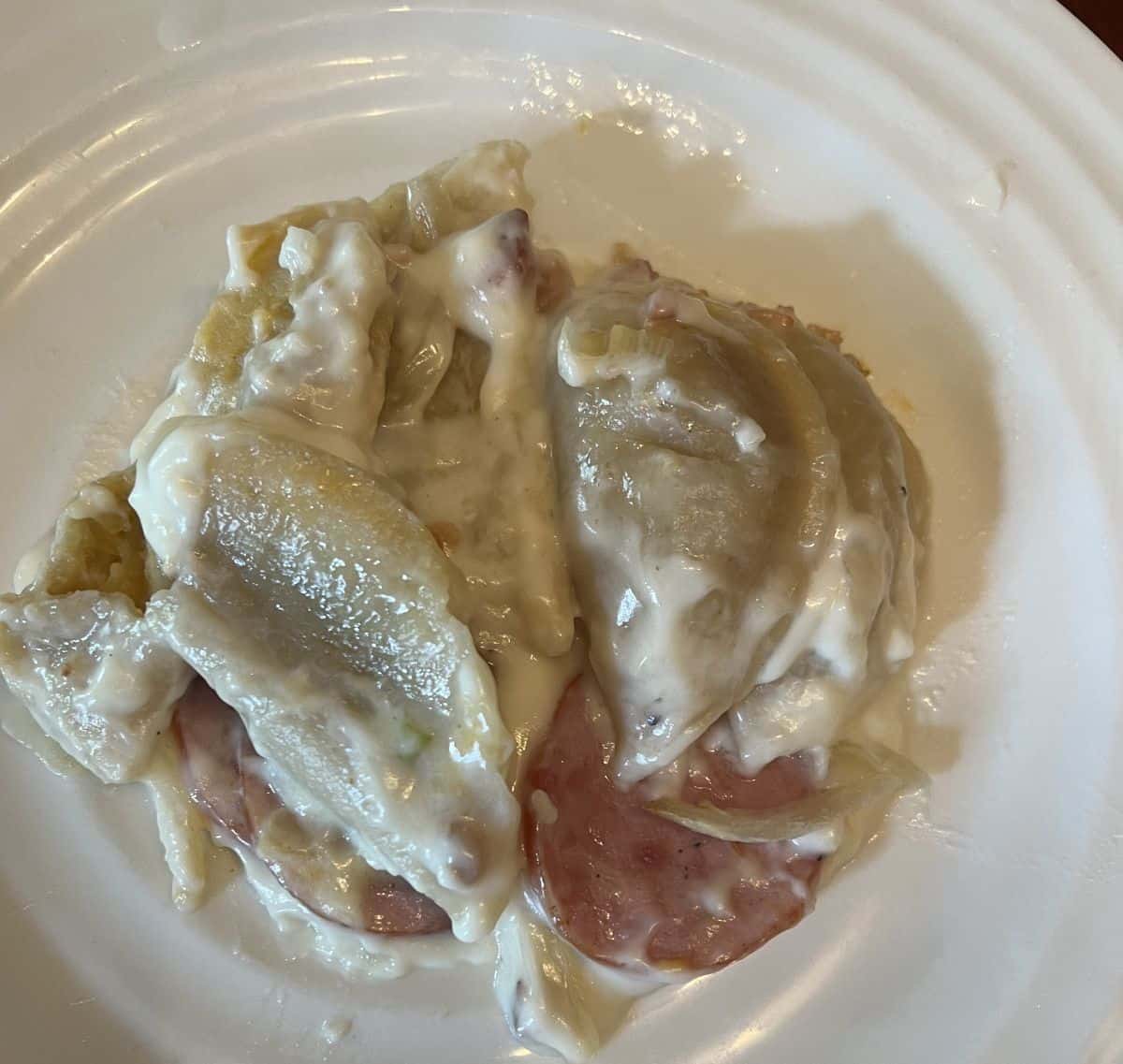 Closeup top down image of the pierogi bake cooked and served on a white plate.