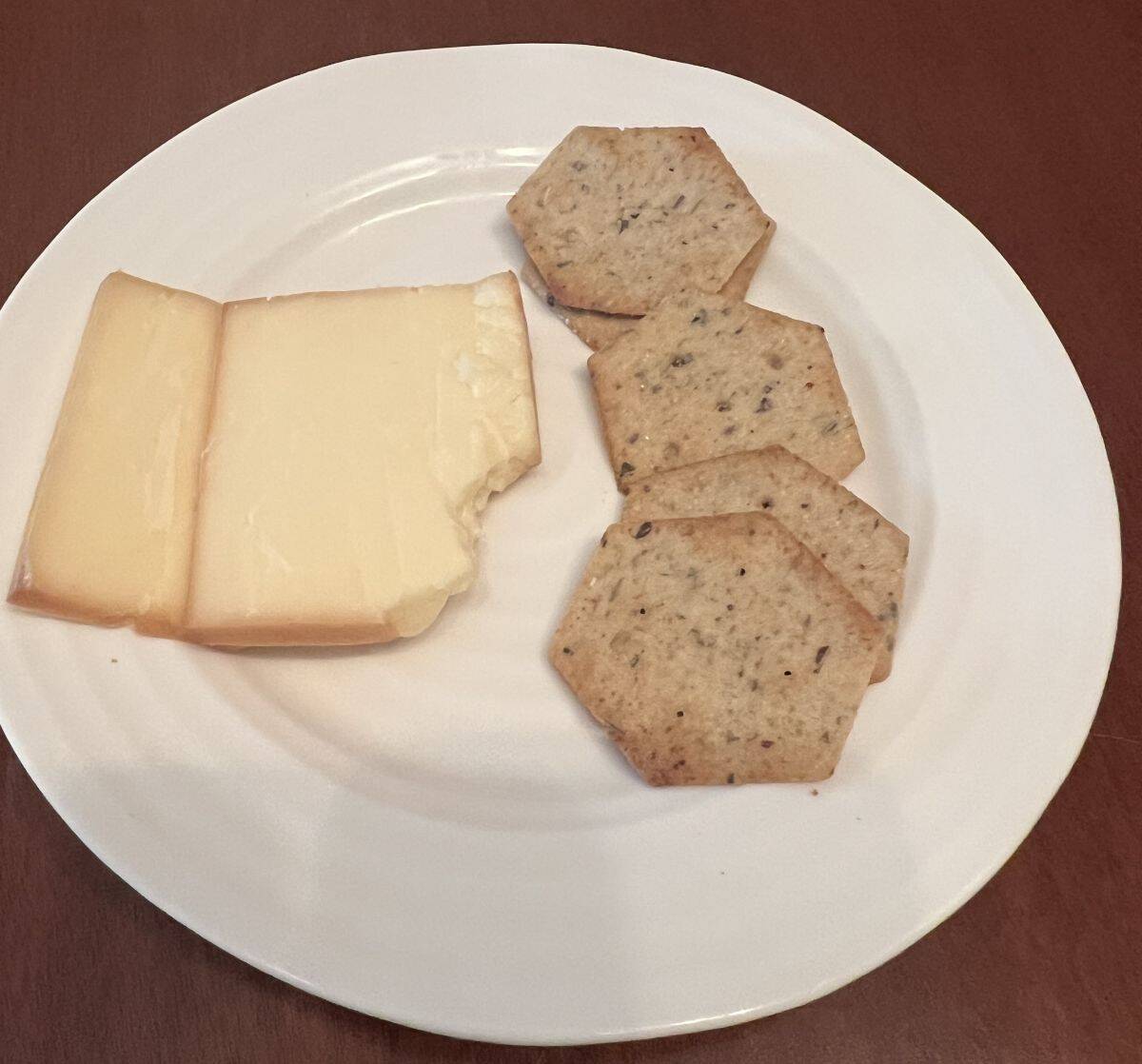 Image of a white plate with smoked cheddar and crackers served on it.