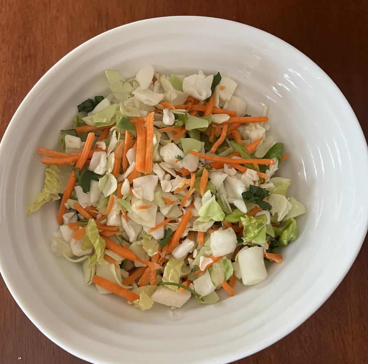 Image of the salad without the toppings or dressing poured into a white bowl.
