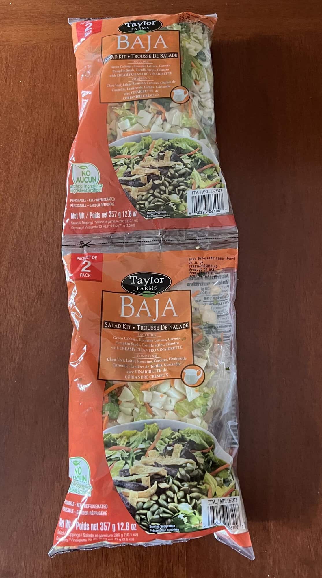 Image of the two-pack of the Costco Taylor Farms Baja Chopped Salad Kit sitting on a table unopened.