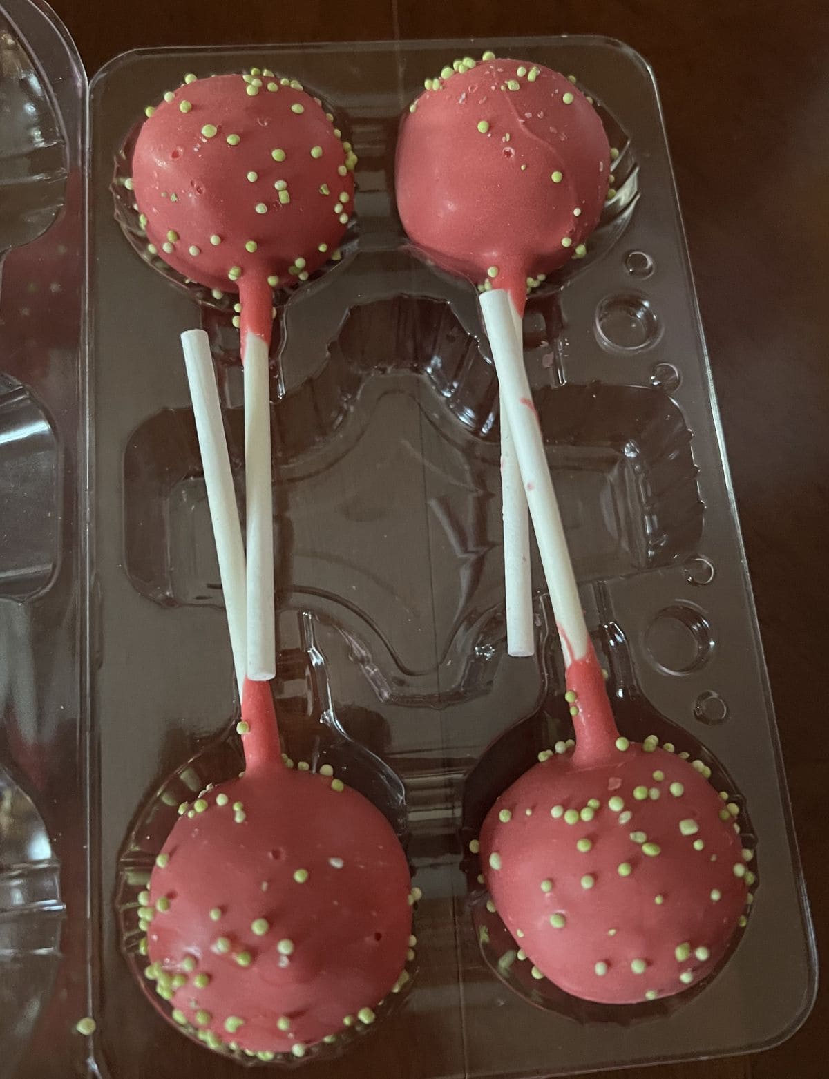 Image of four red cake pops in a plastic container.
