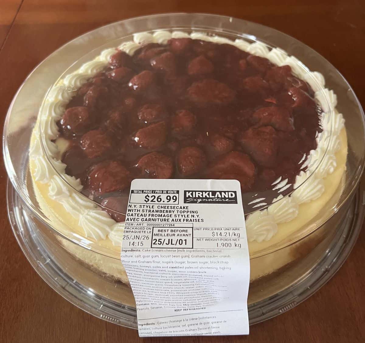 Image of the Costco Kirkland Signature New York Style Strawberry Cheesecake sitting on a table unopened.