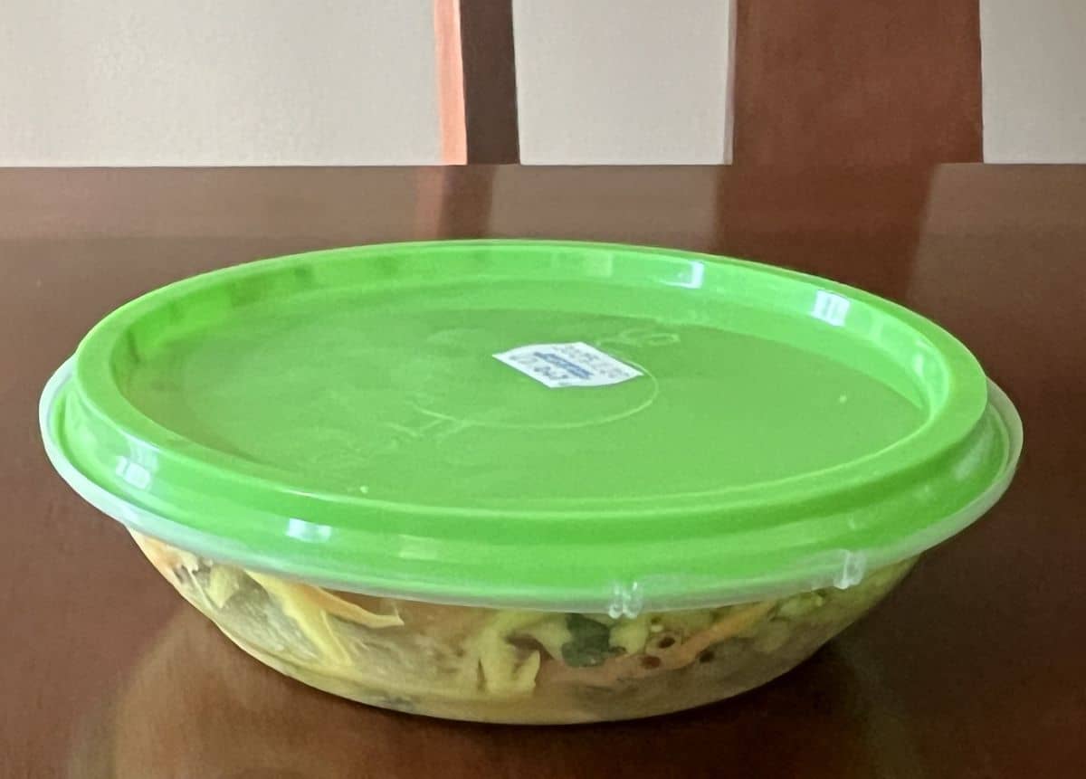 Image of a sealed individual container of the crunchy grain salad, sitting on a table.
