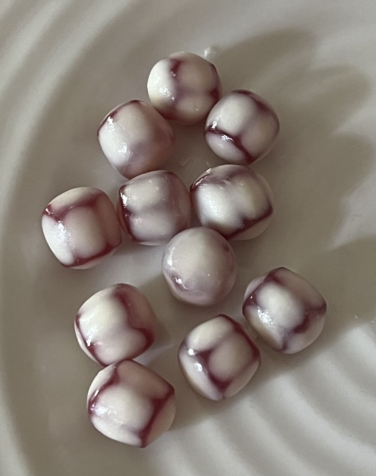 Top down image of the strawberry fruit snacks served on a white plate.
