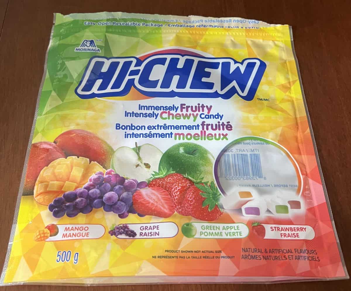 Closeup image of the empty Hi Chew bag laying on a table. It shows the weight of the bag and the flavors.