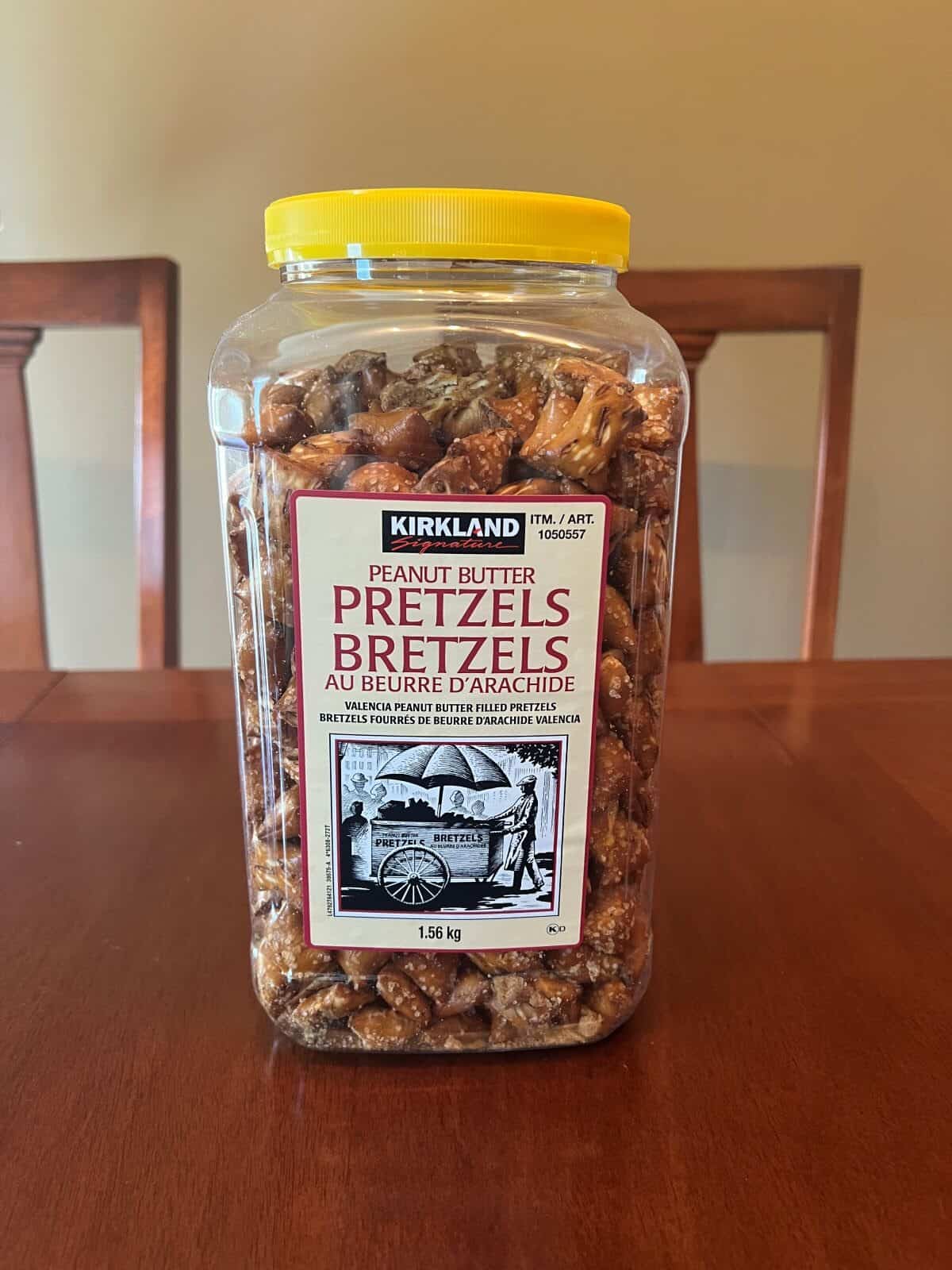Image of the Costco Kirkland Signature Peanut Butter Pretzels container sitting on a table unopened. 