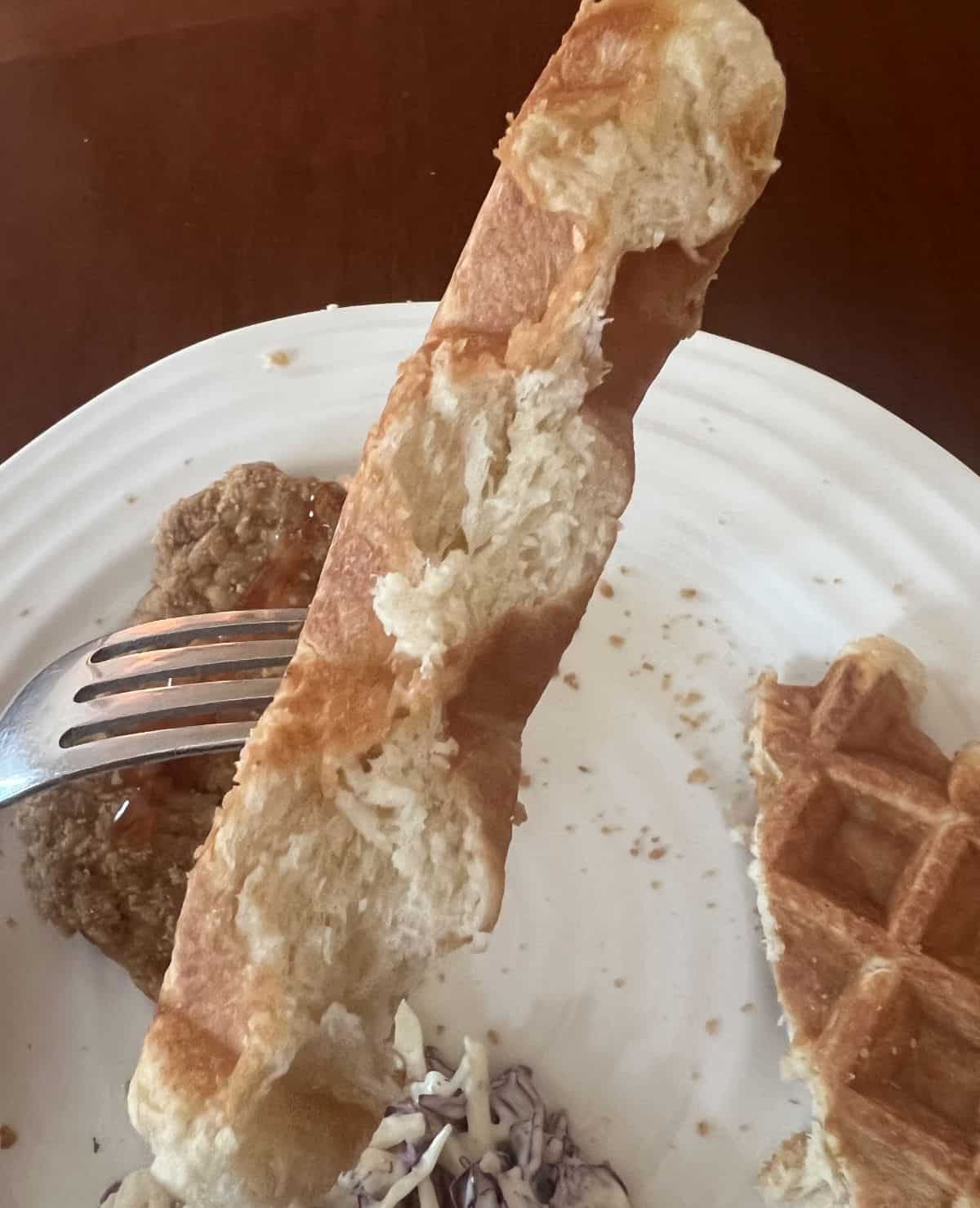 Closeup image of a fork with a piece of waffle on it so you can see the inside of the waffle.