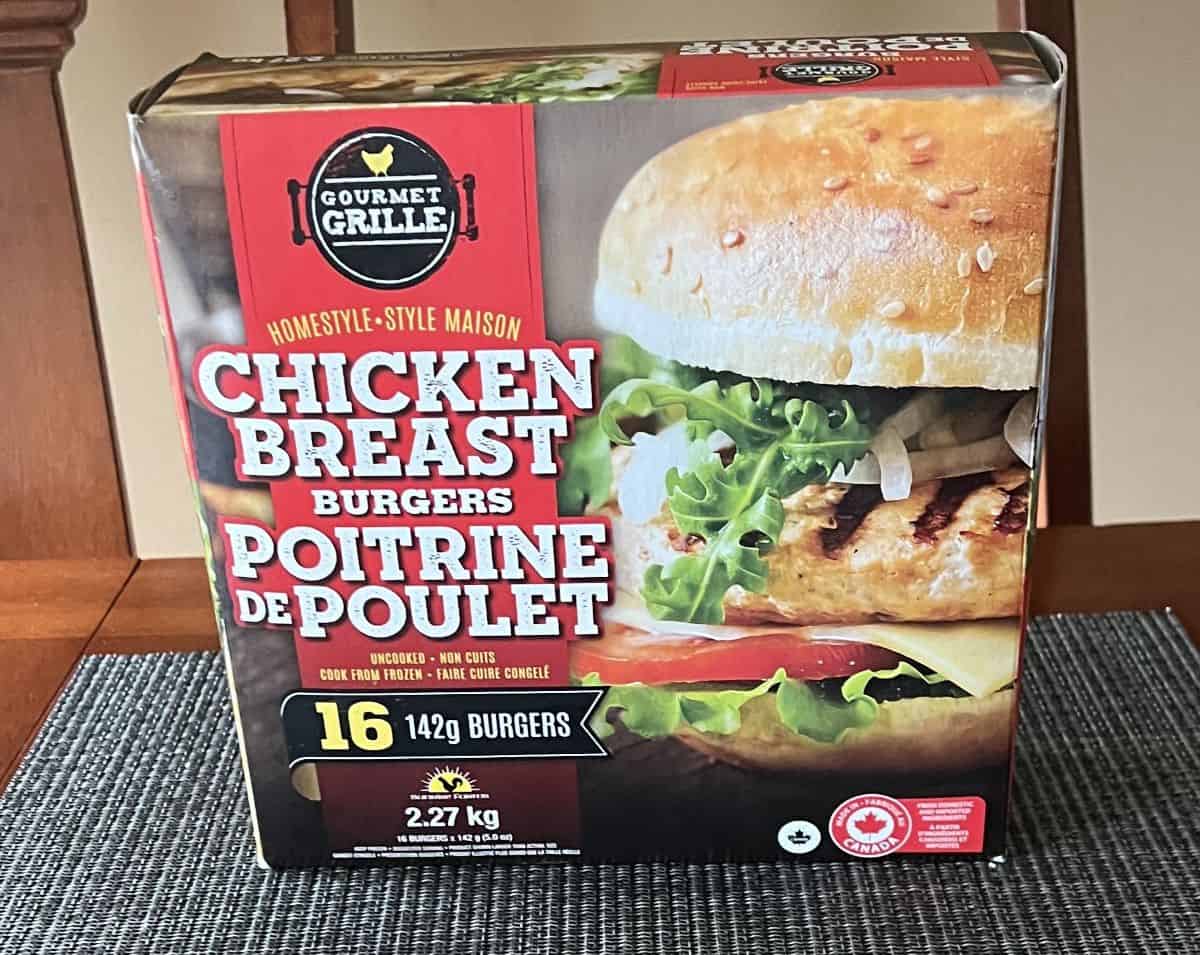 Image of the Costco Gourmet Grille Chicken Breast Burgers box sitting on a table unopened. 