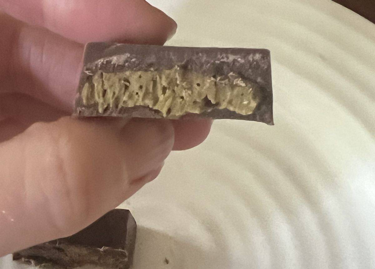 Closeup image of the Dubai chocolate cut in half so you can see the pistachio cream filling. 