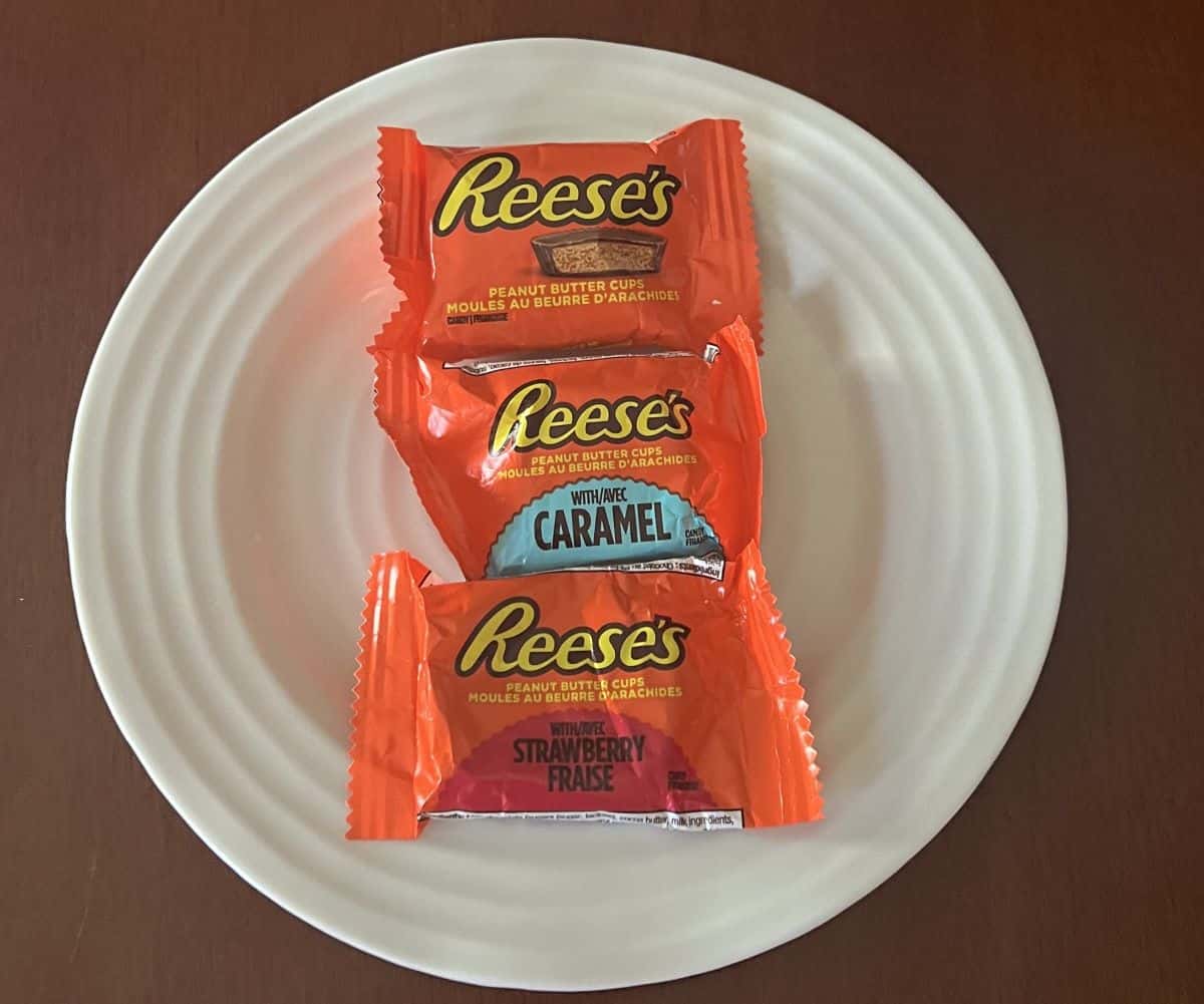 Image of three wrapped Reese's Peanut Butter Cups in three different flavors sitting on a white plate. 