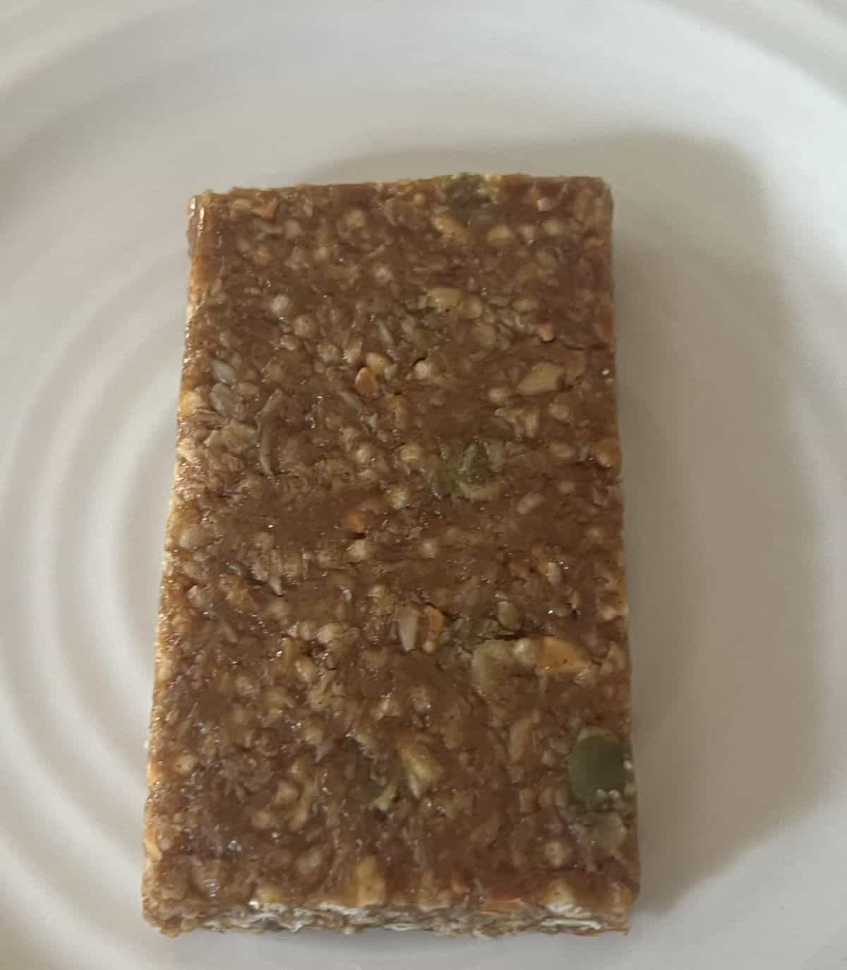 Top down image of one honey cinnamon peanut butter bar unwrapped and served on a white plate.