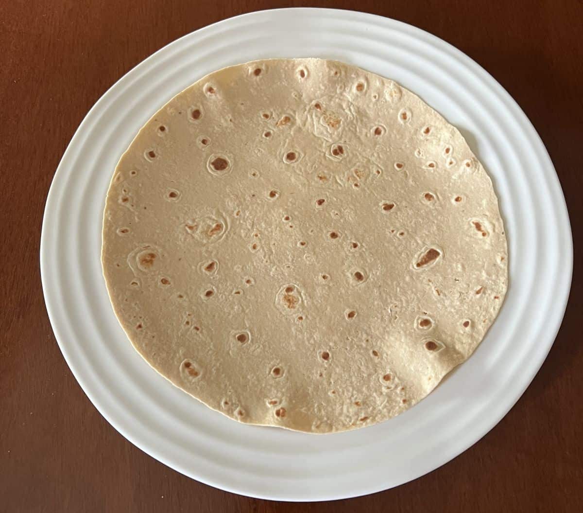 Image of one tortilla served on a white plate.