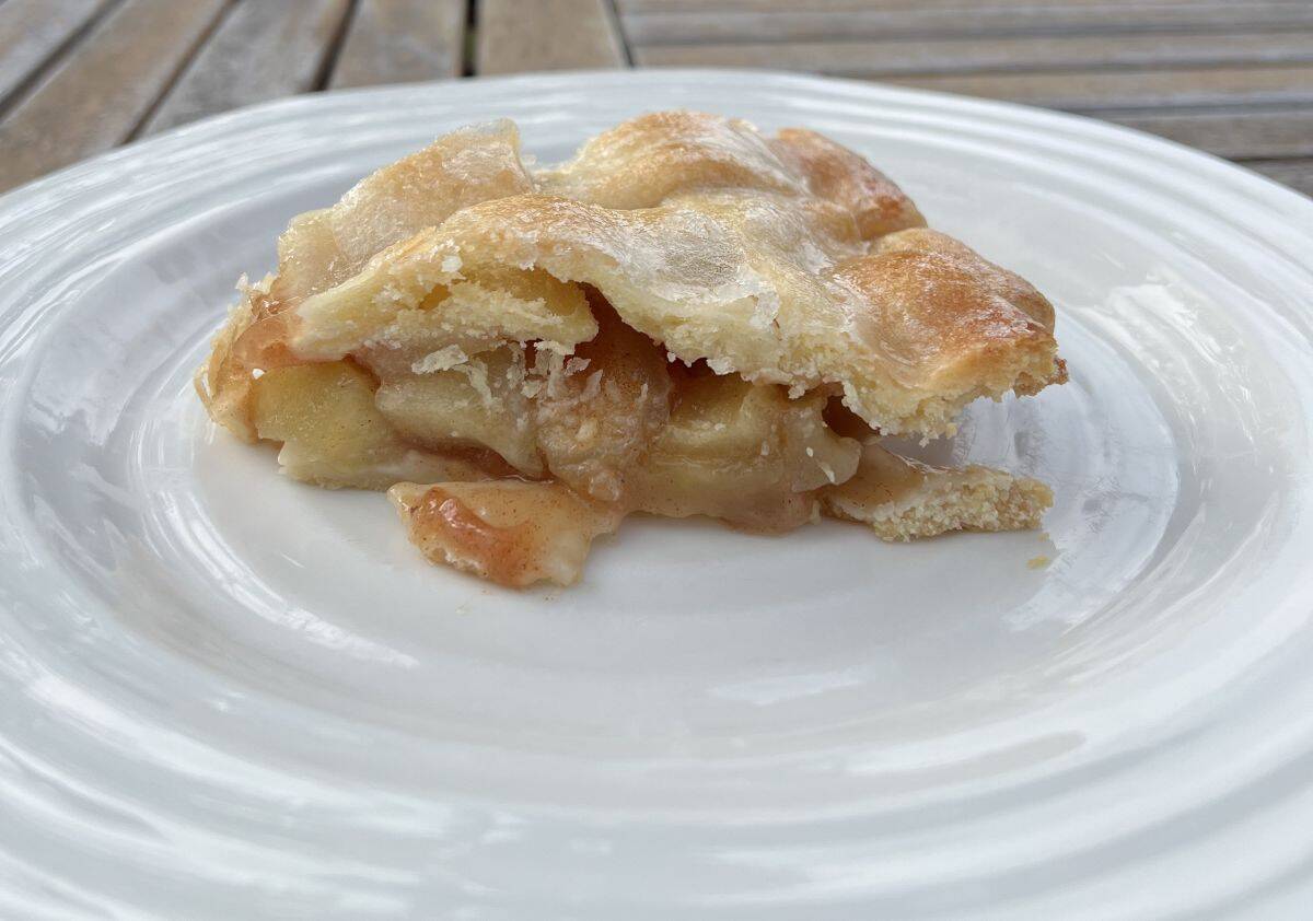 Sideview image of a slice of apple pie served on a white plate. 