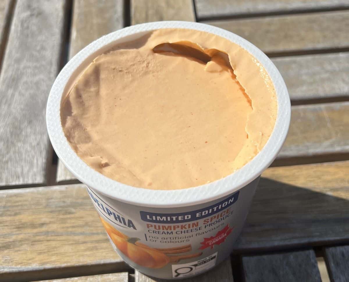 Top down image of an open tub of the pumpkin spice cream cheese.