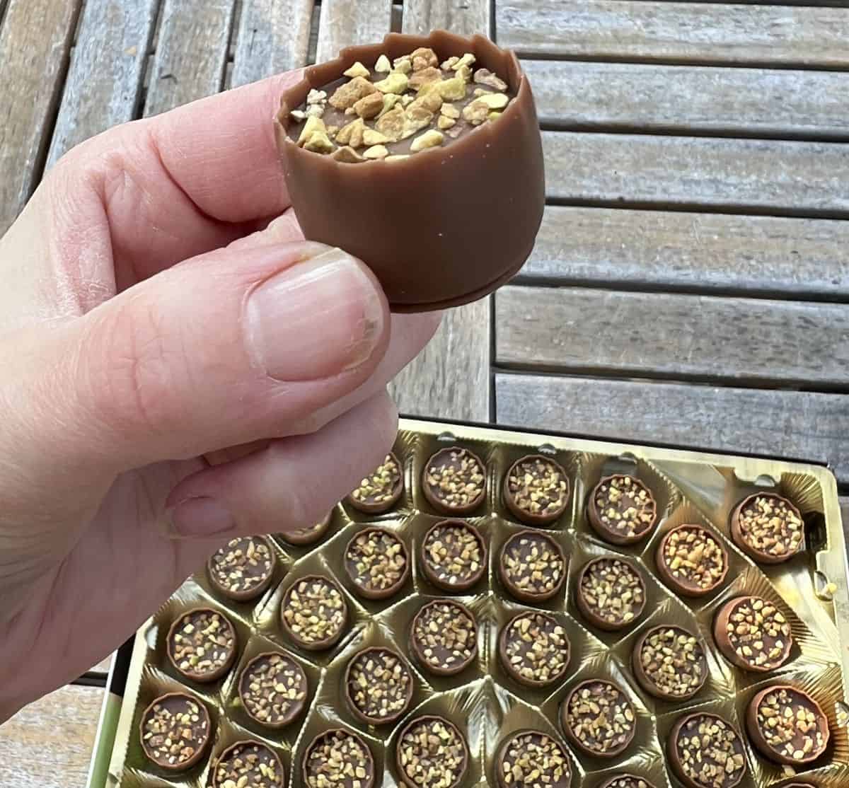 Closeup image of a hand holding one Bouchard Dubai Chocolate close to the camera.