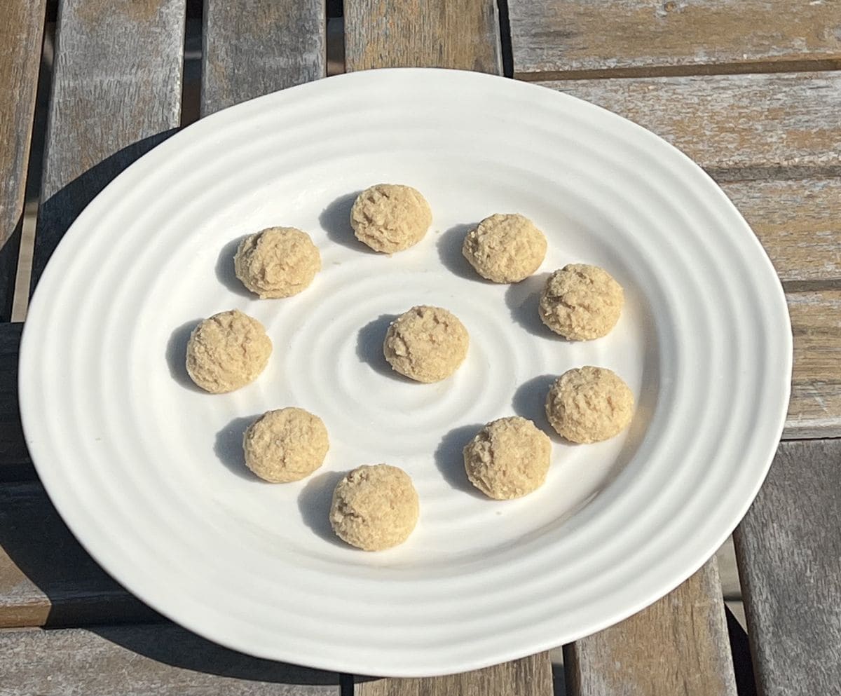 Top down image of a white plate with mini cookies served on it.