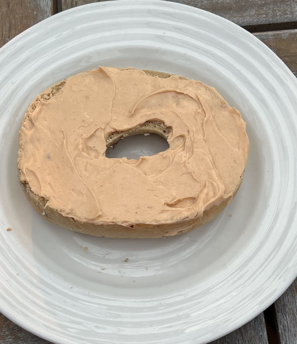 Image of pumpkin spice cream cheese spread on a bagel.