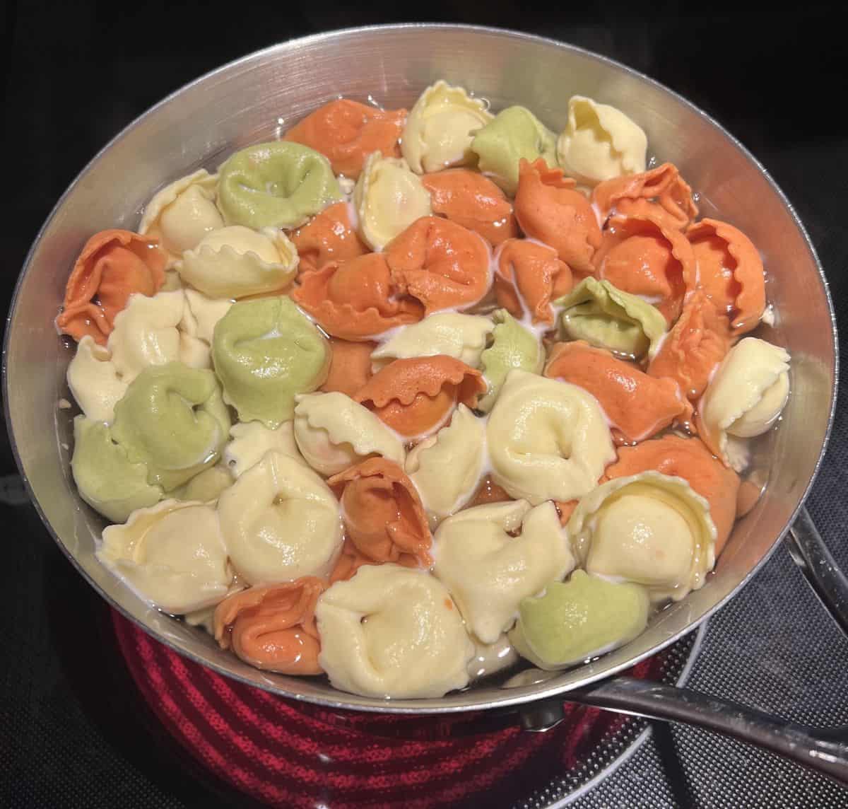 Image of the tortellini being boiled in a pot. 