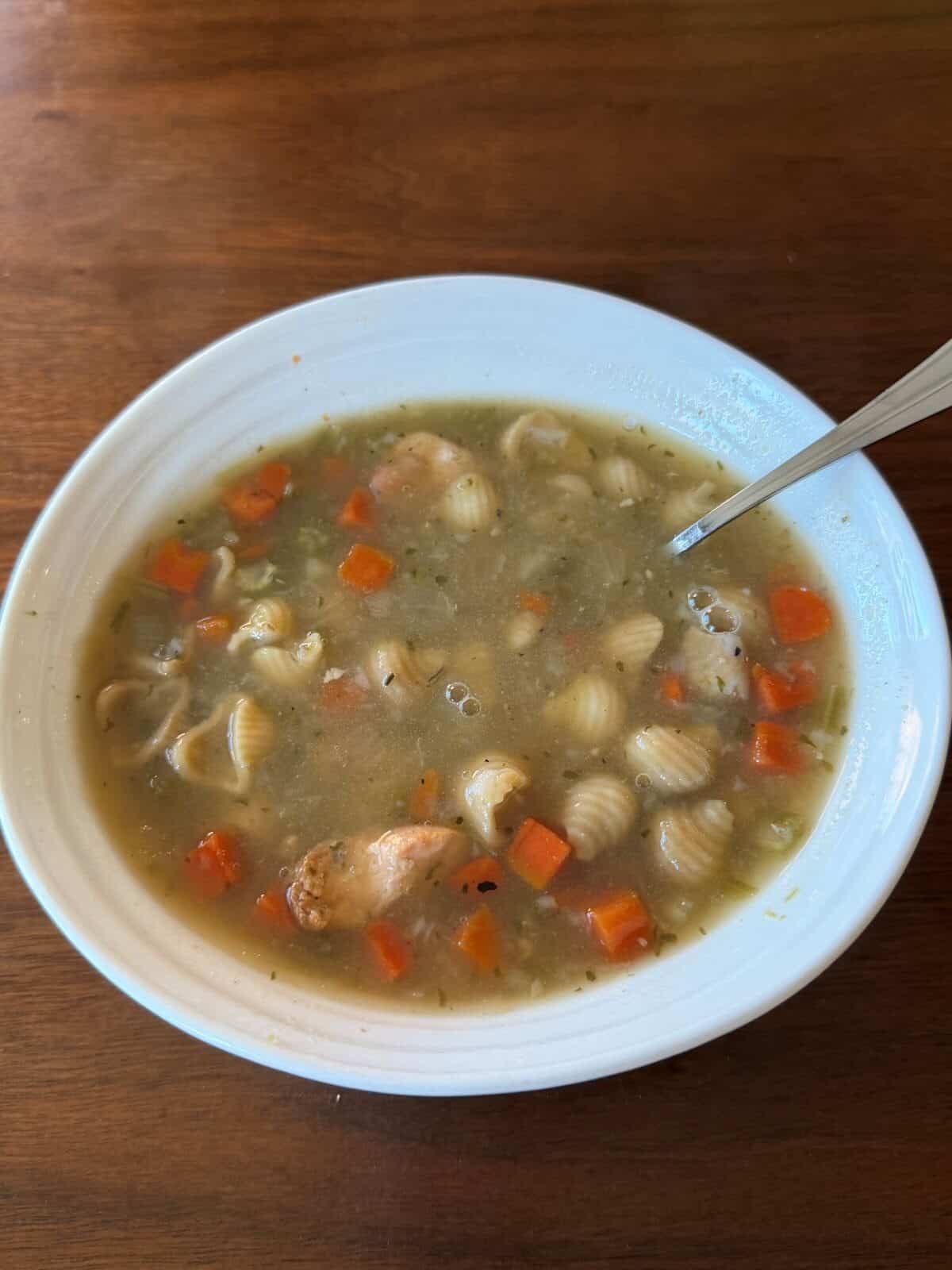 Top down image of a bowl of chicken noodle soup.