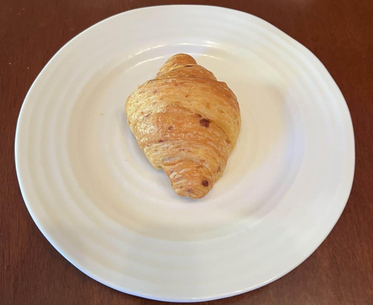 Image of one cheese croissant served on a white plate.