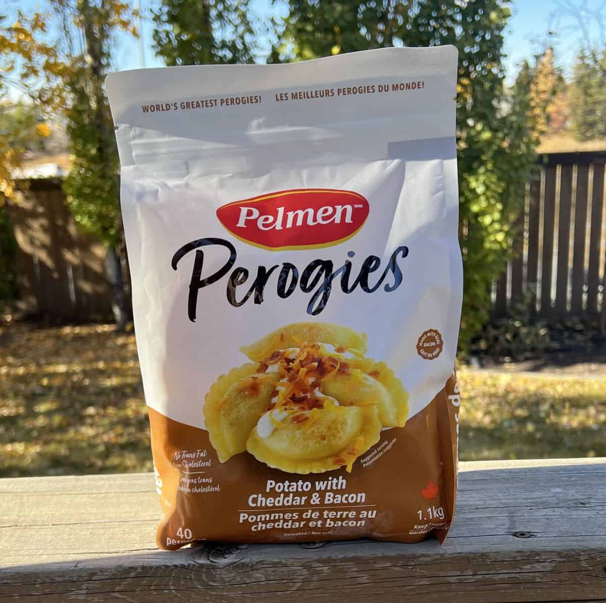 Image of the Costco Pelmen Perogies unopened bag sitting on a deck outside. 