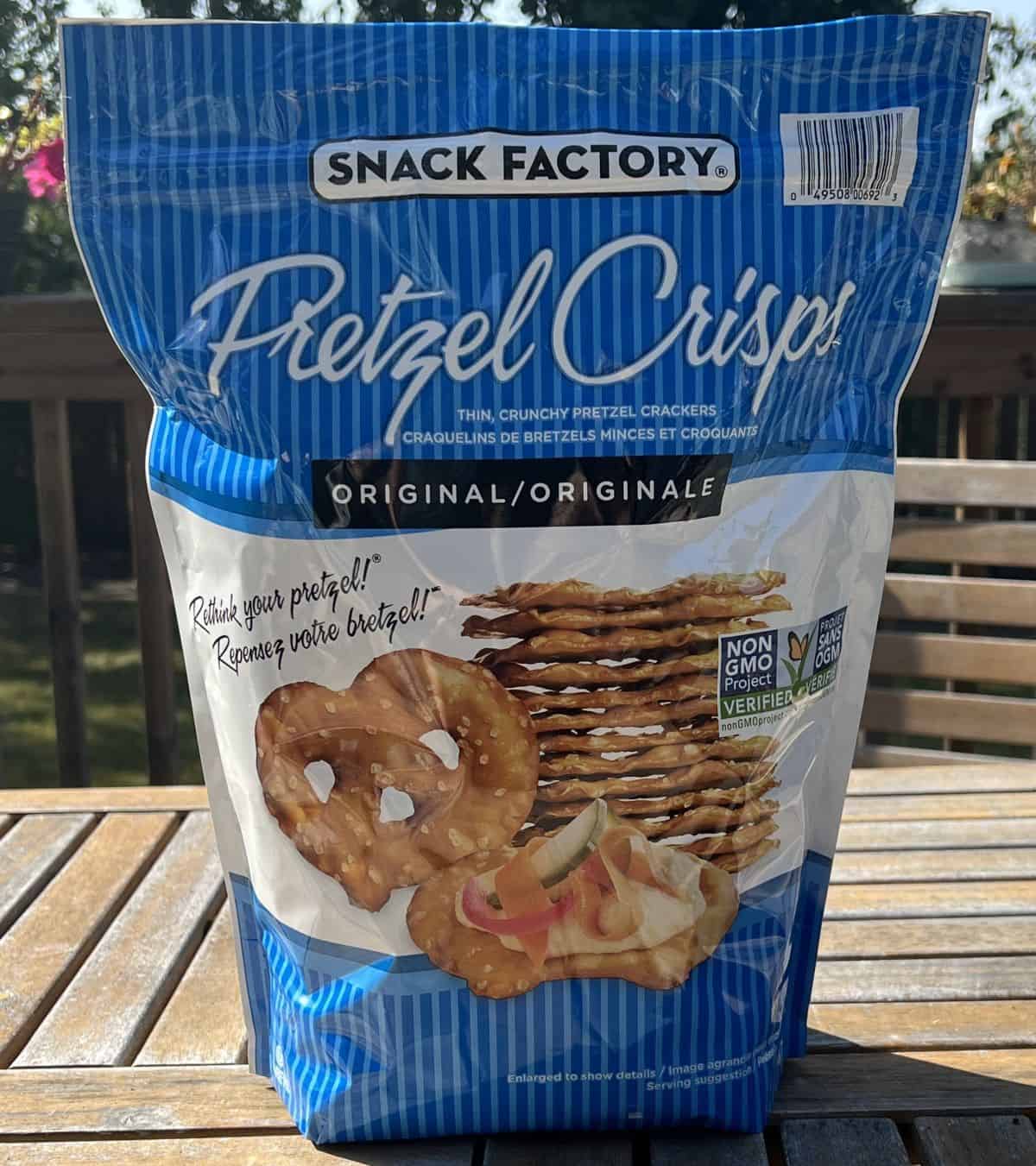 Image of the Costco Snack Factory Pretzel Crisps bag sitting on table outside on a deck.