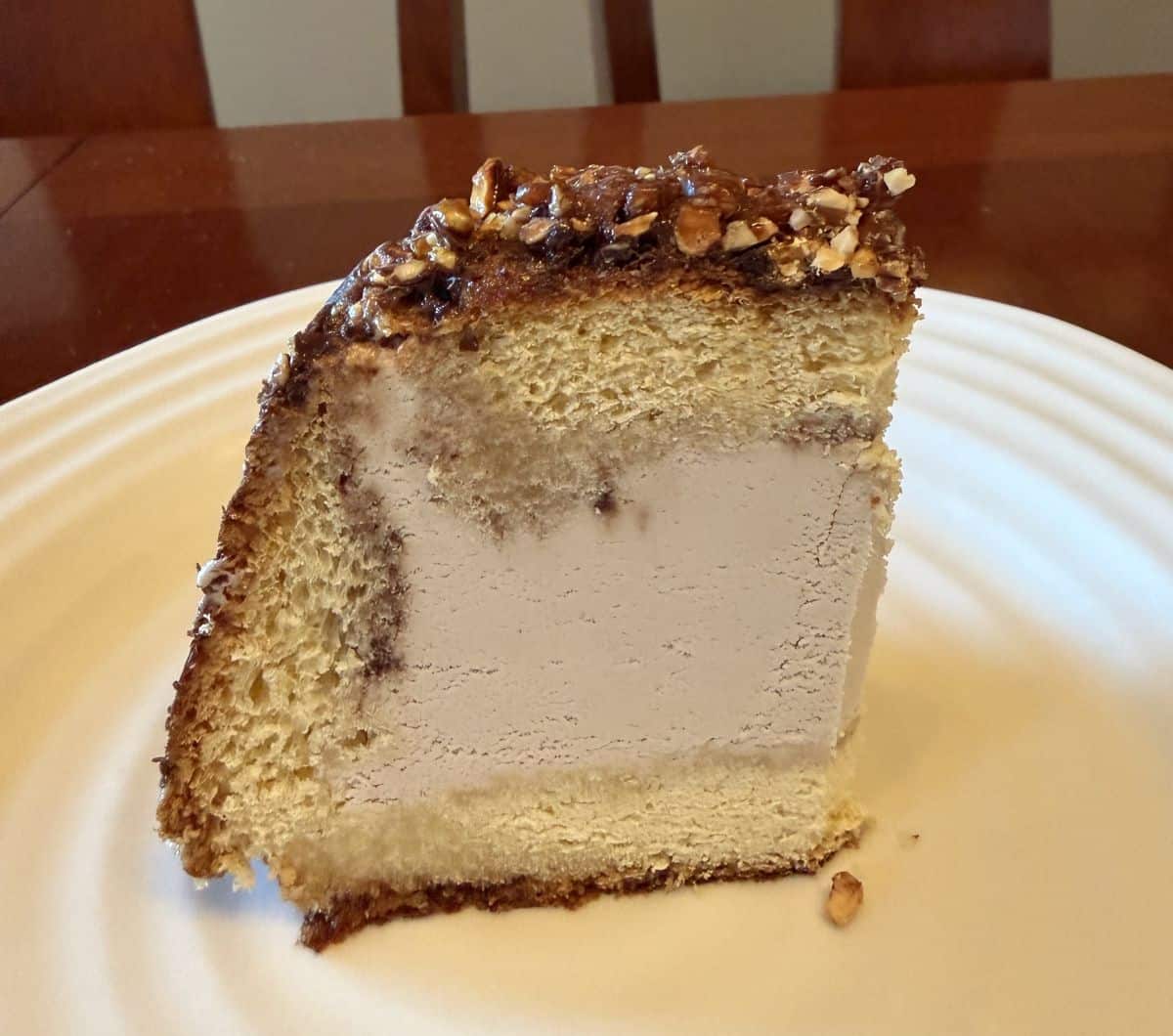 Image of one slice of ice cream cake on a white plate.
