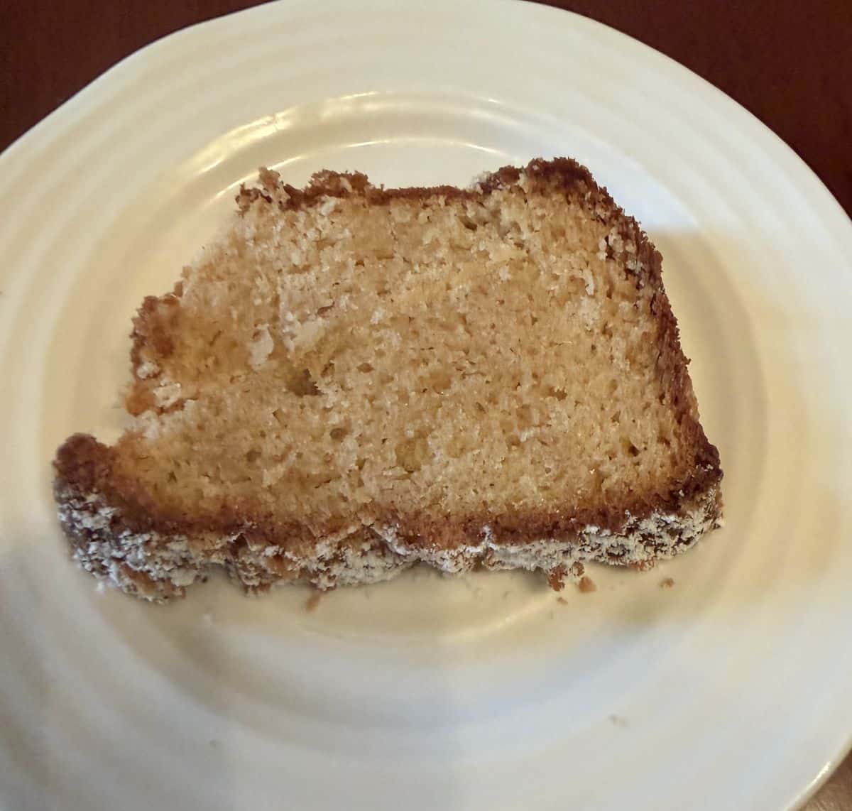 Image of one slice of the loaf cake, served on a white plate.