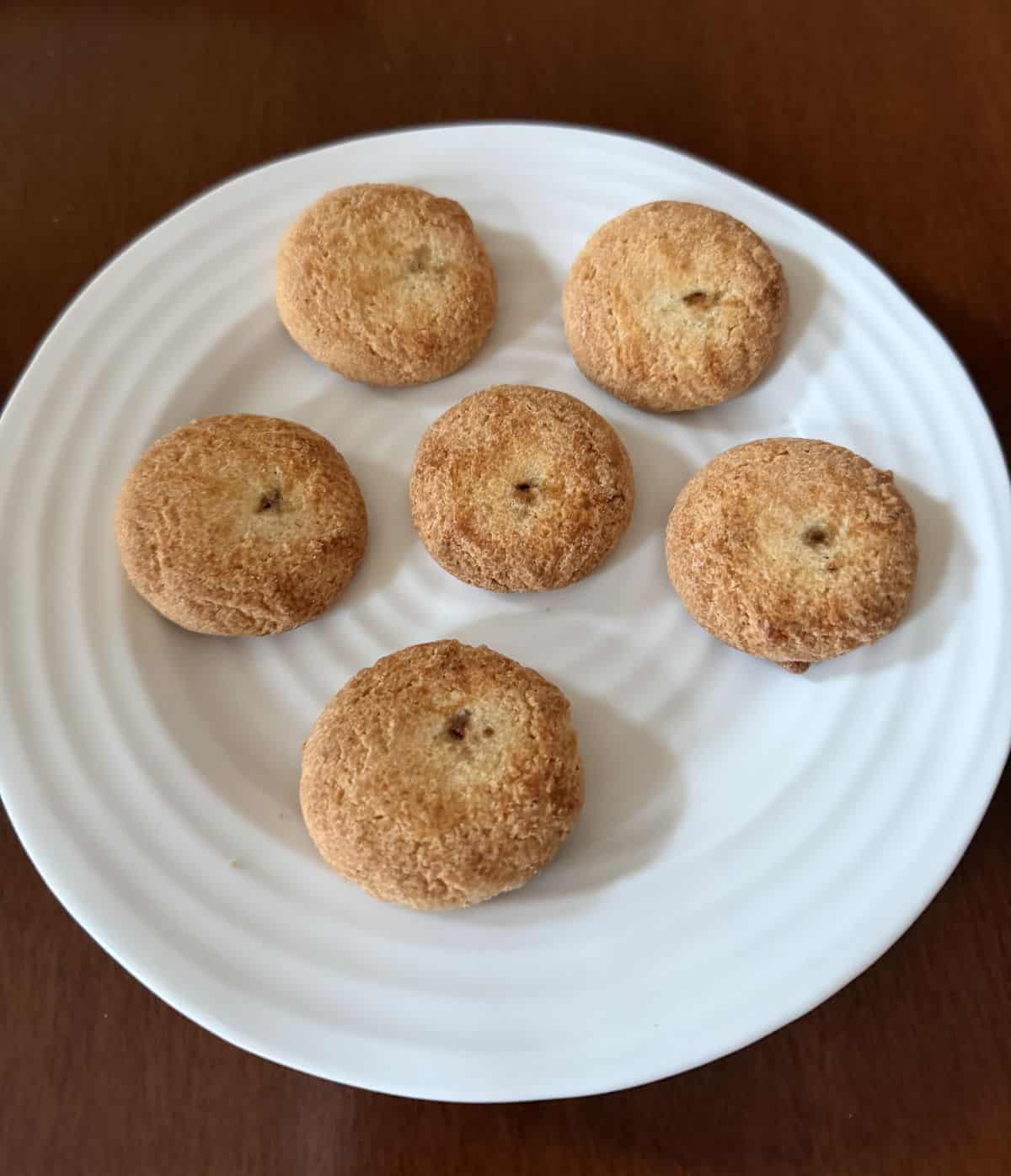 Image of six cookies served on a white plate. 
