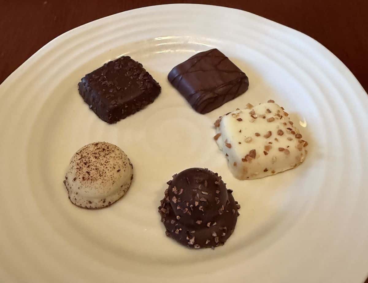 Closeup side view image of five different kinds of biscuits served on a white plate.