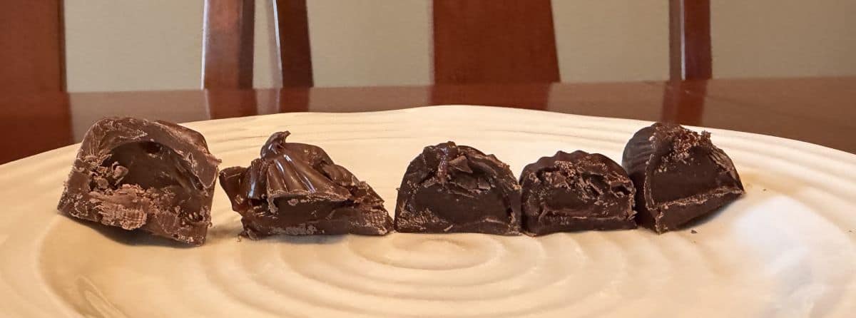 Image of the five different kinds of chocolates cut in half and served on a white plate. 