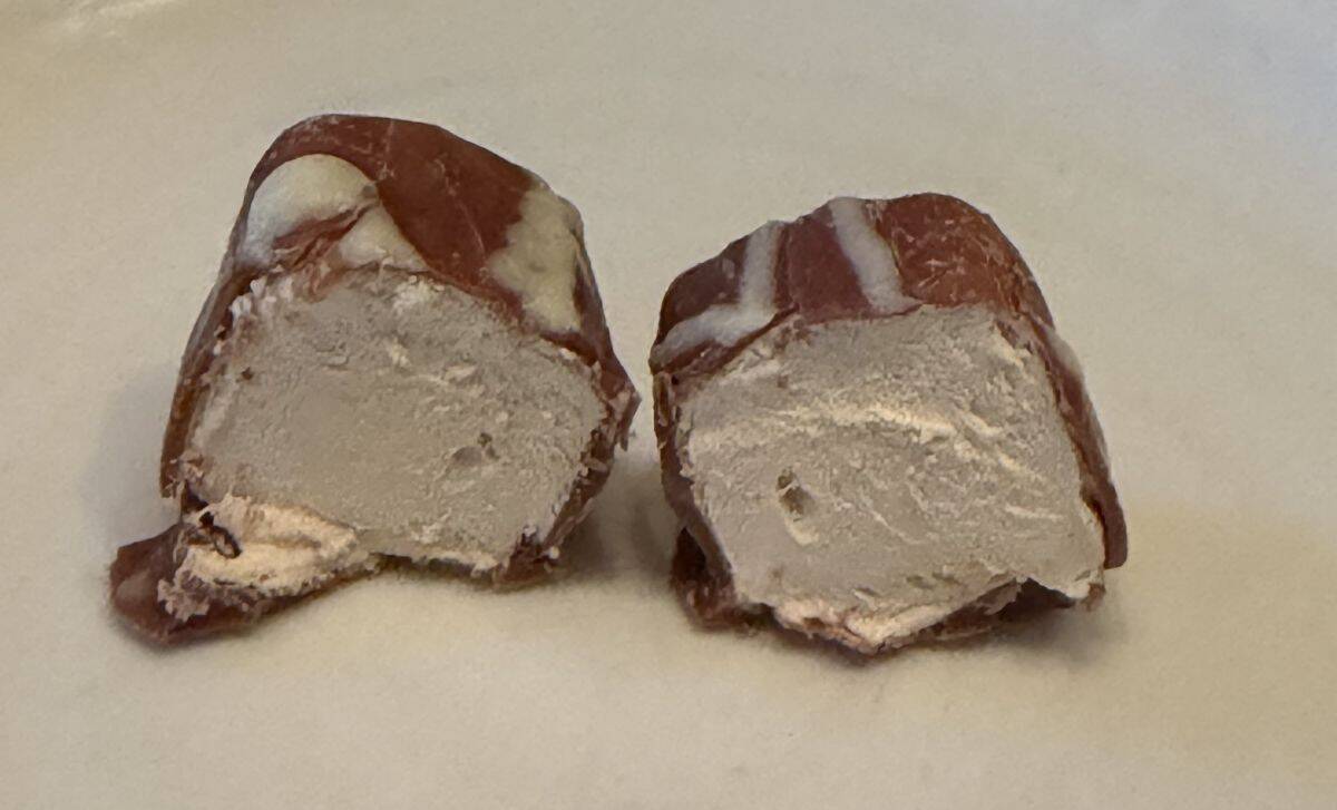 Image of one sea salt caramel Mallow with Belgian chocolate cut in half so you can see the inside.