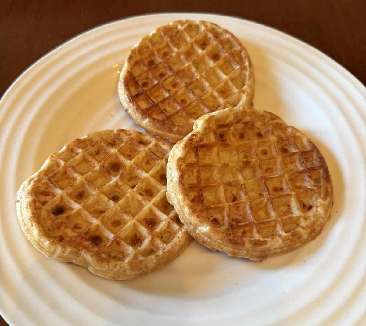Image of three toasted waffles served on a white plate.