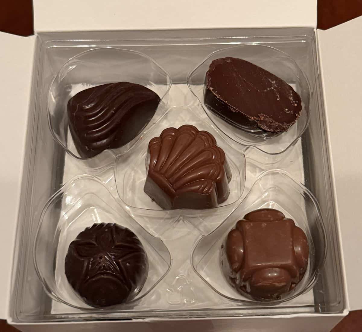 Top down image of a plastic tray in the box of chocolates, in the tray is five chocolates. 